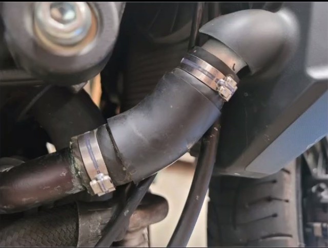 Close-up of Oetiker ear clamps on a car radiator hose, highlighting the clamp type and location