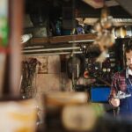 Professional mechanic thoughtfully selects a tool from a well-organized toolbox