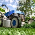 Modern lawn mower cutting grass in a sunny garden