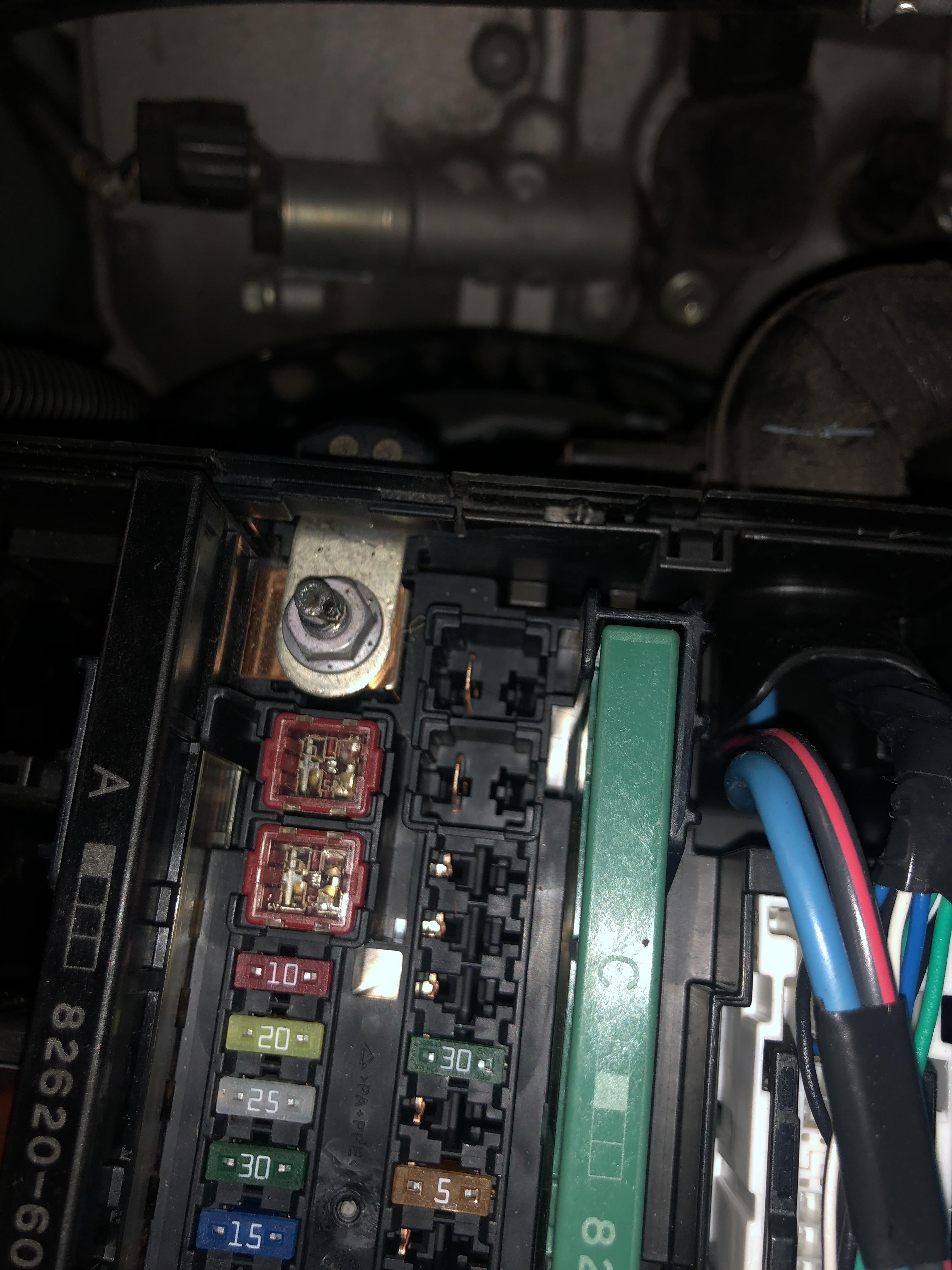 Car fuse box with highlighted bolt where arcing occurred