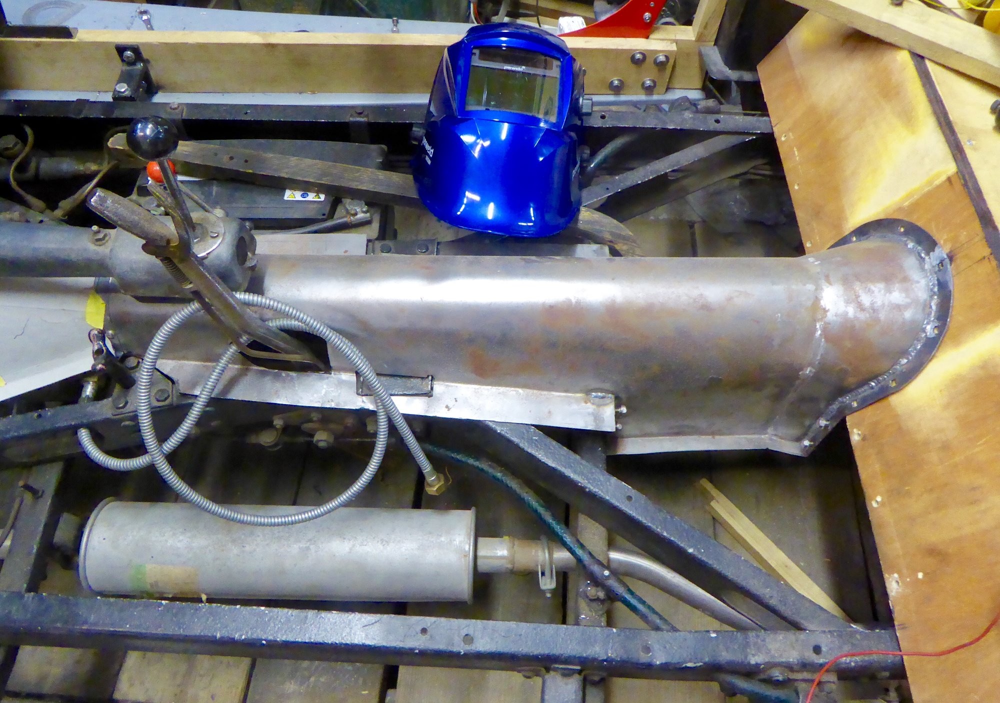 alt text: A technician using a die grinder with a roloc disc to smooth a weld on car sheet metal.