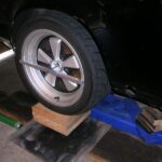 alt text: Aluminum mounting bar attached to a wheel for alignment.