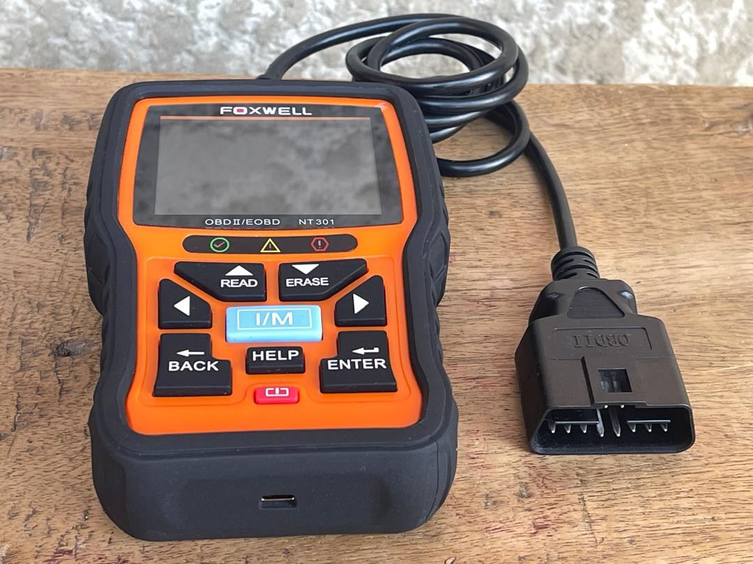 Foxwell NT301 connected to a car's OBD2 port.