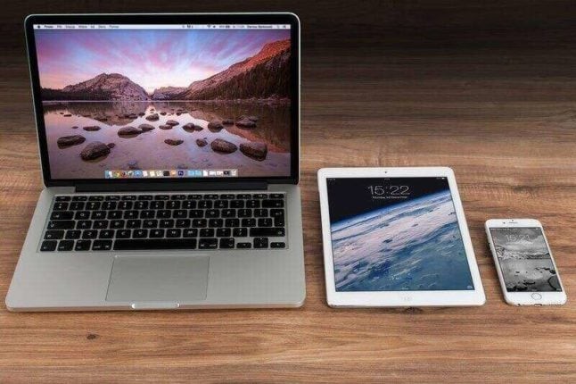 laptop, tablet, and iphone sitting on wooden desk