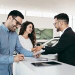 Modern car dealership showroom with salespeople and customers